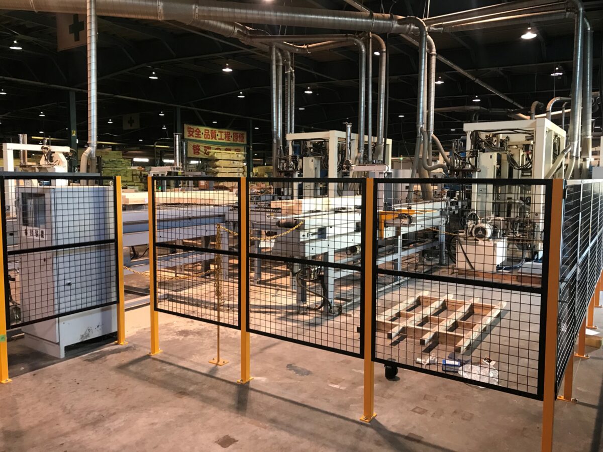 施工後：コンベア設備と作業者をメッシュフェンスで分離した製材工場